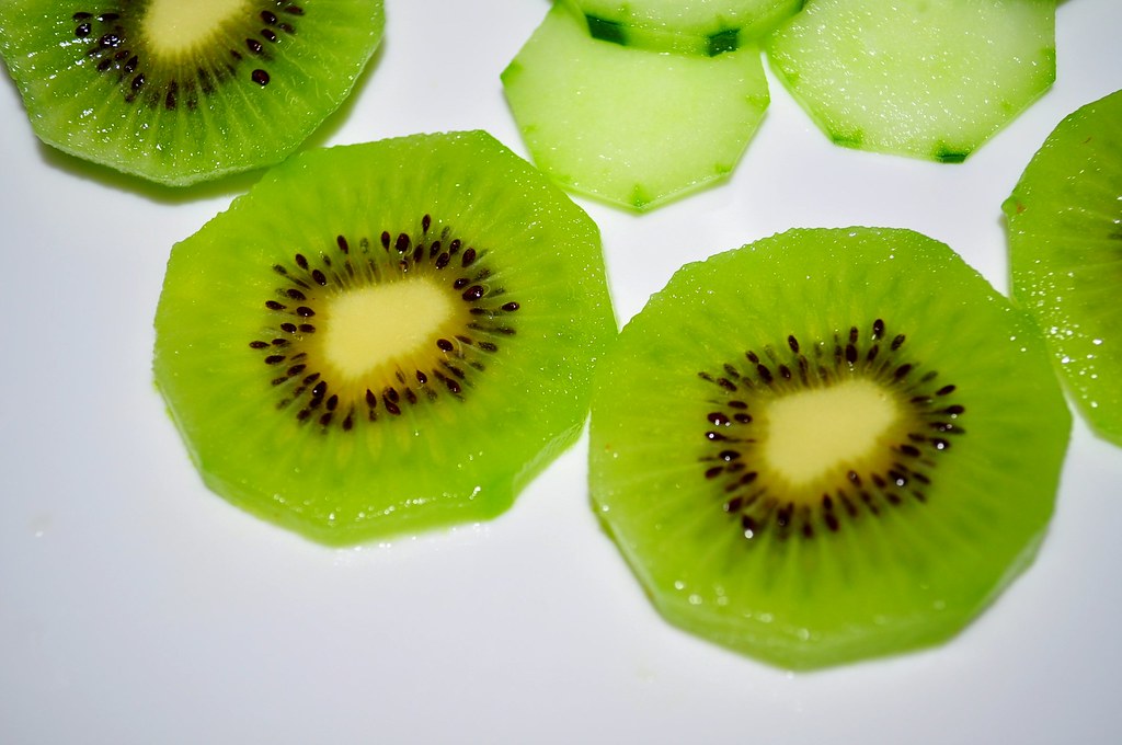 Sliced kiwi fruit arranged on a plate.